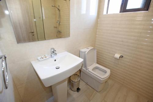 a bathroom with a sink and a toilet and a mirror at Hotel Star in Sarandë