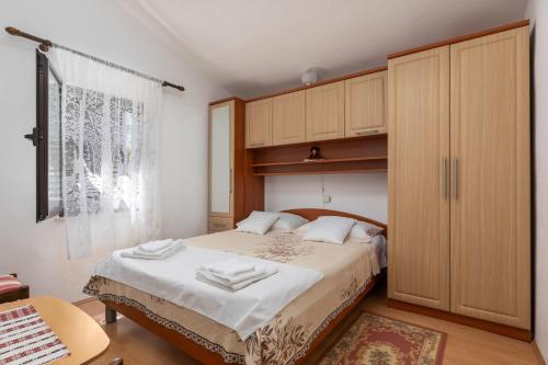 ein Schlafzimmer mit einem großen Bett und einem Holzschrank in der Unterkunft Apartman Matea in Sveti Lovreč Pazenatički