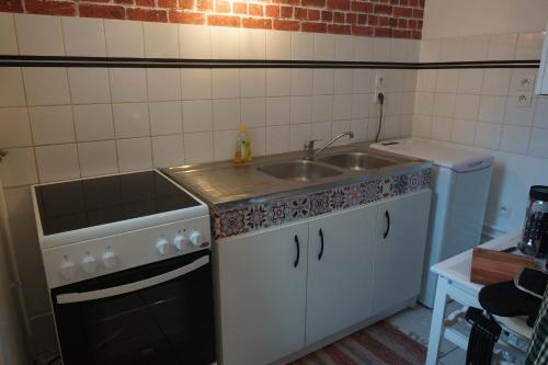 a small kitchen with a sink and a stove at Le Pompidou T2 pour 2 à 4 pers avec parking privé & balcon Place Ney in Angers