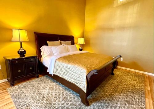 a bedroom with a bed and a nightstand with two lamps at Inn on Main Hotel in Manasquan