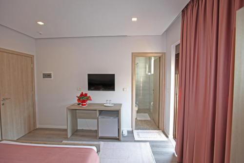 a room with a table and a television in a room at Hotel Star in Sarandë