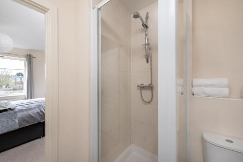 a white bathroom with a shower and a toilet at Virexxa Bletchley - Executive Suite - 2Bed Flat with Free Parking in Milton Keynes