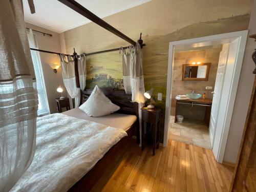 a bedroom with a bed and a bathroom with a sink at Park Villa Gernsheim in Gernsheim