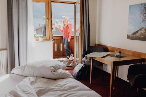 a woman standing in a room looking out the window at Dorfcafe Unken Hotelpension sWirtshaus im Dorf in Unken