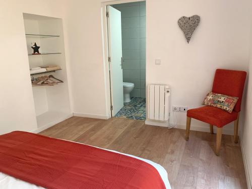 a bedroom with a bed and a chair and a bathroom at RomanticHome at Alfama's Heart in Lisbon