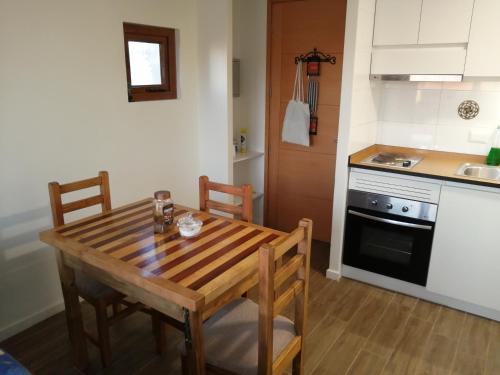 a kitchen with a wooden table with chairs and a stove at Departamento 1D 1B, Puerto Montt in Puerto Montt