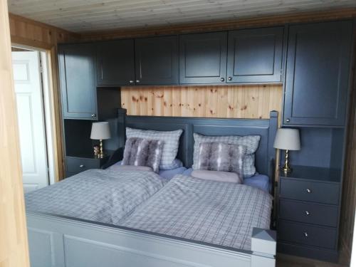 a bedroom with a bed with blue cabinets at Ferienhaus Fjellblikken in Sinnes