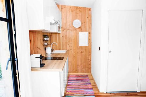 a small kitchen with white cabinets and a rug at Beach House in Lège-Cap-Ferret