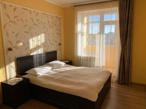 a bedroom with a large bed with a window at Luxury apartment 2 in Truskavets