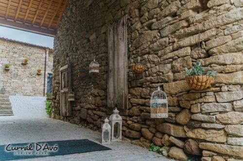 a stone building with a bird cage on the side of it at Curral D Avó Turismo Rural & SPA in Caçarelhos