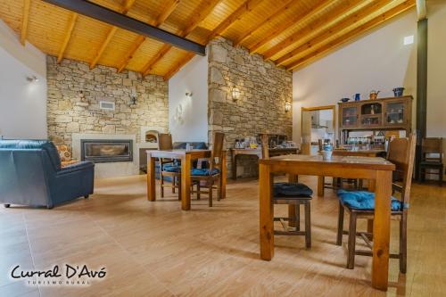 uma sala de estar com uma mesa e uma lareira em Curral D Avó Turismo Rural & SPA em Caçarelhos