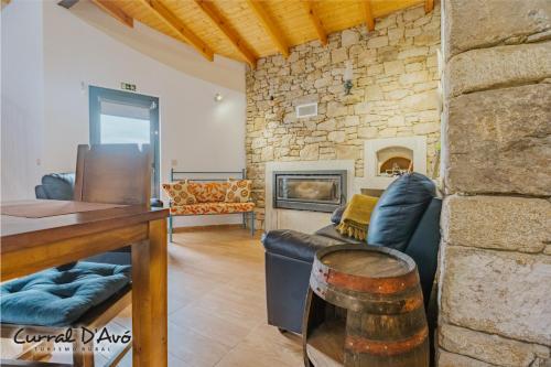 a living room with a couch and a fireplace at Curral D Avó Turismo Rural & SPA in Caçarelhos