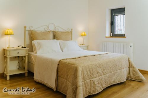 a bedroom with a large bed and two night stands at Curral D Avó Turismo Rural & SPA in Caçarelhos