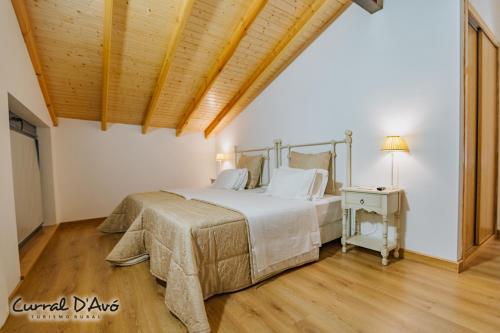 a bedroom with a large bed and a wooden ceiling at Curral D Avó Turismo Rural & SPA in Caçarelhos