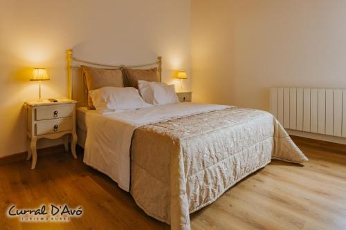 a bedroom with a large bed and a night stand at Curral D Avó Turismo Rural & SPA in Caçarelhos