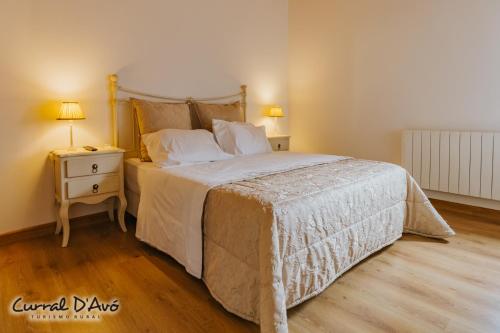 a bedroom with a large bed and a night stand at Curral D Avó Turismo Rural & SPA in Caçarelhos