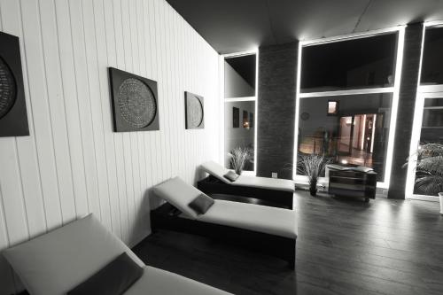 a living room with two white couches in a room at Therme 51° Hotel Physio & Spa in Leukerbad