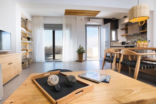 a kitchen and living room with a table and chairs at Amer Villa Santorini with outdoor hot tub in Vóthon