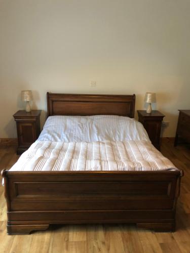 a bed in a bedroom with two end tables at The Bungalow Knockreagh Farm Kilkenny R95AX50 in Callan