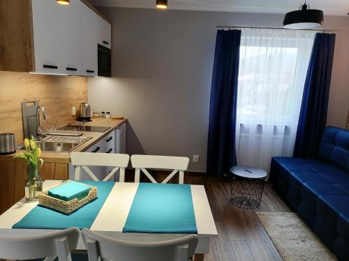 シュクラルスカ・ポレンバにあるWilla pod lasemのリビングルーム(テーブル、青いソファ付)