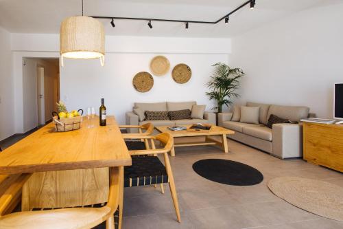 a living room with a table and a couch at Amer Villa Santorini with outdoor hot tub in Vóthon