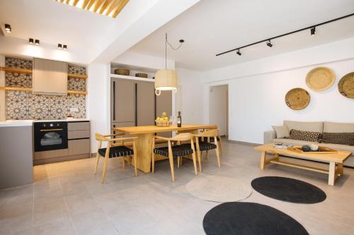 a kitchen and living room with a table and a couch at Amer Villa Santorini with outdoor hot tub in Vóthon