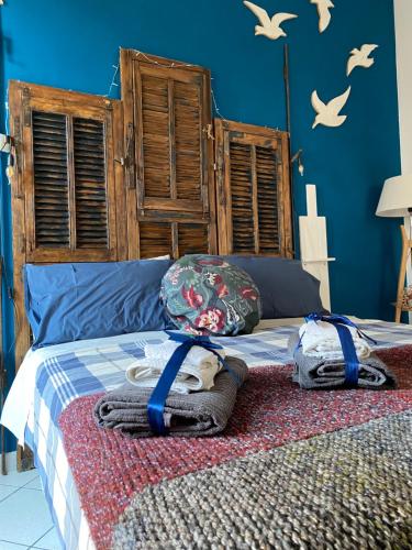 a bed with a blanket and towels on it at Casetta del borghetto -Nel cuore del Borghetto in Nettuno