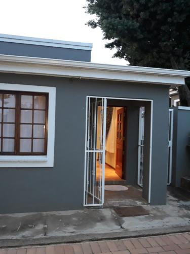 a blue house with a door and a window at Fancy Pansy in Germiston