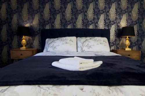 a bed with two lamps and two towels on it at Holden House in Shardlow