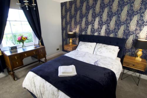 a bedroom with a bed with a blue comforter at Holden House in Shardlow