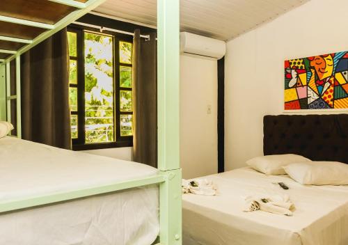 two beds in a room with two windows at Lonier Villa Inn Economic in Abraão
