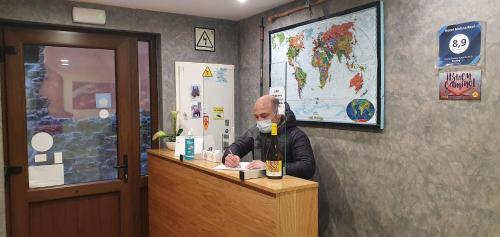 a man sitting at a counter with a bottle of wine at Hotel Casa Ramon Molina Real in Molinaseca