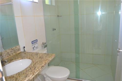 La salle de bains est pourvue de toilettes, d'un lavabo et d'une douche. dans l'établissement Pousada e Restaurante Kambuká, à Mucuri