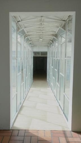an empty hallway in an empty building with glass corridors at Hara Palace Hotel in Curitiba
