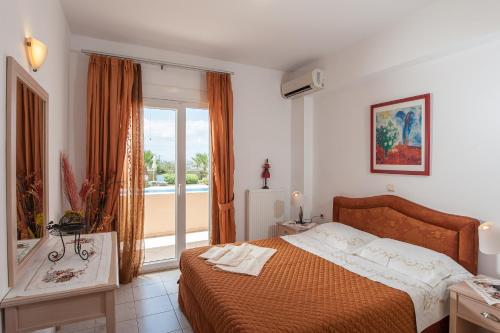 a bedroom with a bed and a large window at VILLA PASIFAI in Tria Monastiria