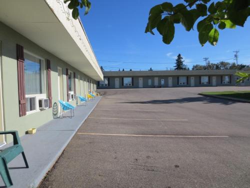 a row of blue chairs sitting outside of a building at Motel and Camping Colibri in Caraquet