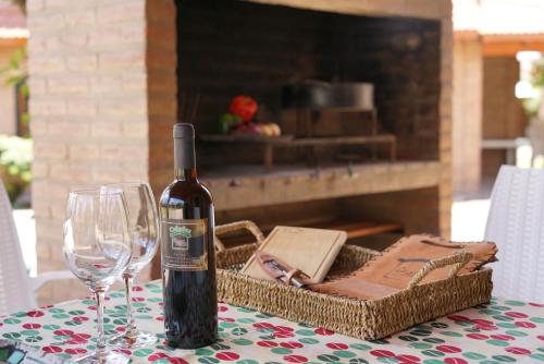 a bottle of wine and two glasses on a table at Cabañas La Aldea in Villa Carlos Paz