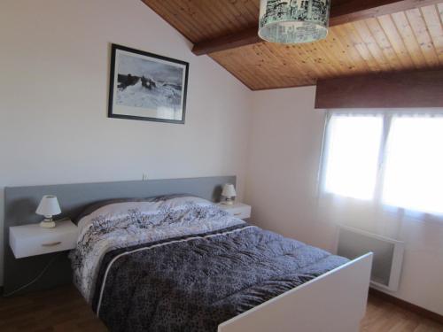 ein Schlafzimmer mit einem Bett und zwei Fenstern in der Unterkunft Maison LES SABLES D'OLONNE 700 m Plage WIFI in La Pironnière