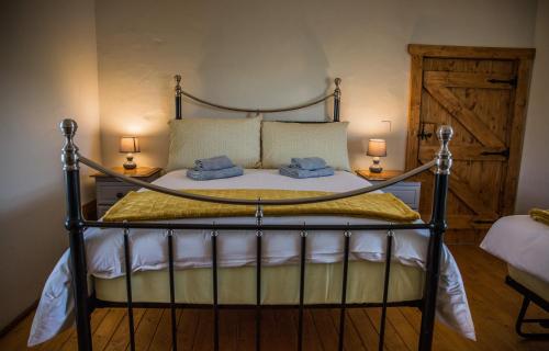 a bedroom with a bed with two pillows and two lamps at Dans Wee Cottage Slieve Croob Dromara Castlewellan Newcastle in Dromara