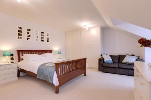 um quarto com uma cama grande e um sofá em Modern Spacious Apartments em Bishop's Stortford