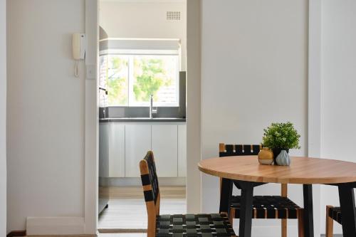 een keuken en eetkamer met een tafel en stoelen bij Garden Apartment - Short Walk to Harbour Bridge in Sydney