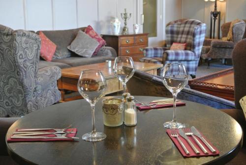 a table with two wine glasses on top of it at Causeway Hotel in Bushmills