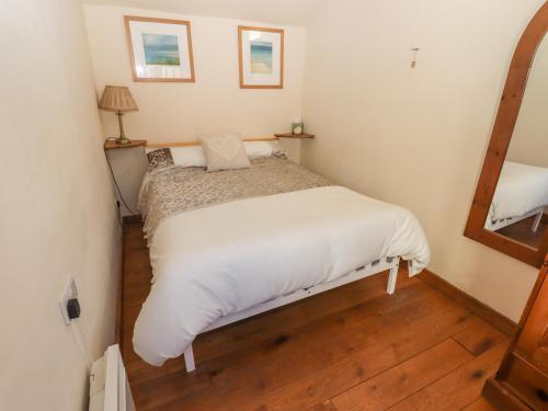 a small bedroom with a bed with white sheets at Top Farm Cottage in Oswestry