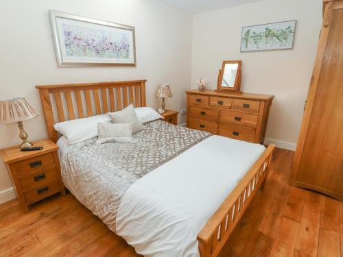 a bedroom with a large bed and two dressers at Top Farm Lodge in Oswestry