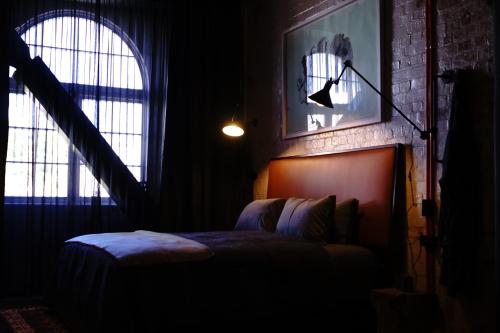 a bedroom with a bed and two windows at The Intrepid Hotel in Wellington