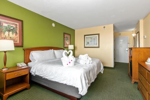 a hotel room with a bed with two stuffed animals on it at Holiday Inn & Suites Clearwater Beach by IHG in Clearwater Beach