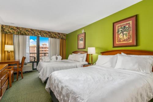 two beds in a hotel room with green walls at Holiday Inn & Suites Clearwater Beach by IHG in Clearwater Beach