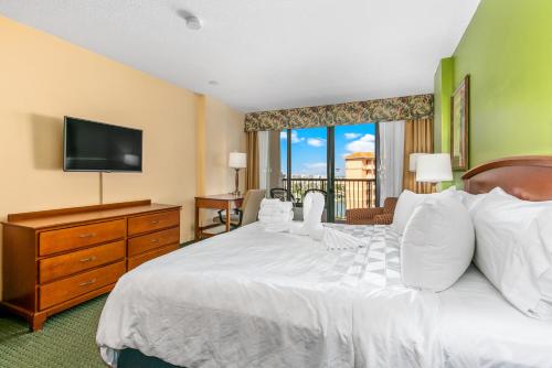a bedroom with a bed with a television and a dresser at Holiday Inn & Suites Clearwater Beach by IHG in Clearwater Beach