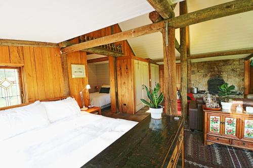 a bedroom with a large white bed and wooden walls at The Chapel at Crackenback in Crackenback