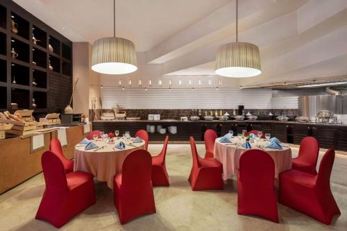 a restaurant with two tables and red chairs at Ramada Plaza by Wyndham Dubai Deira in Dubai